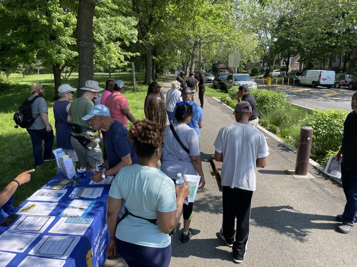 People gathered at table along Cobbs Creek Trail.
